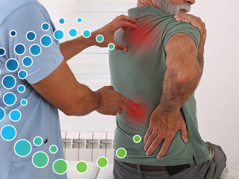 Man at a doctor office showing the doctor his back with two red pain points where the doctor's hand touch his back.